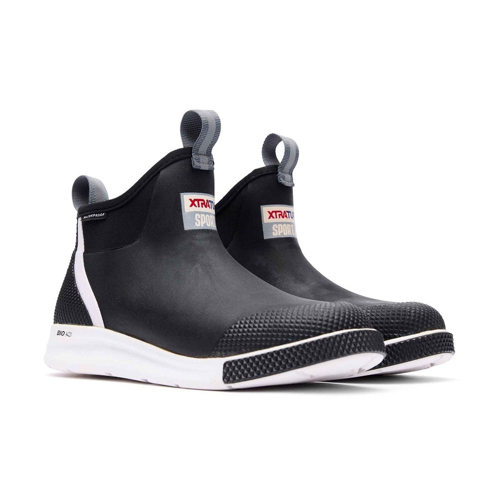 Black XTRATUF Ankle Deck Sport Boots with white soles, textured toe, and pull tabs.