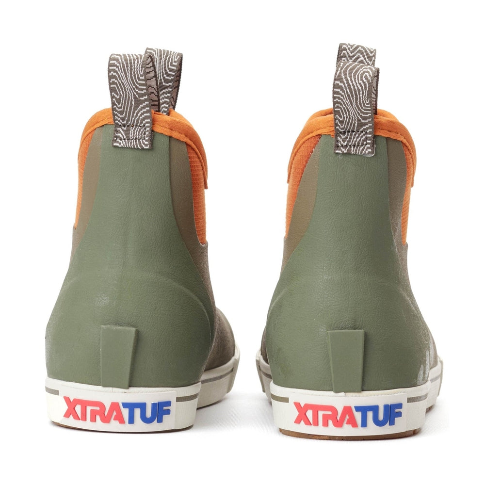 Pair of olive green XTRATUF Ankle Deck Camp Boots with orange neoprene cuffs and patterned pull tabs.