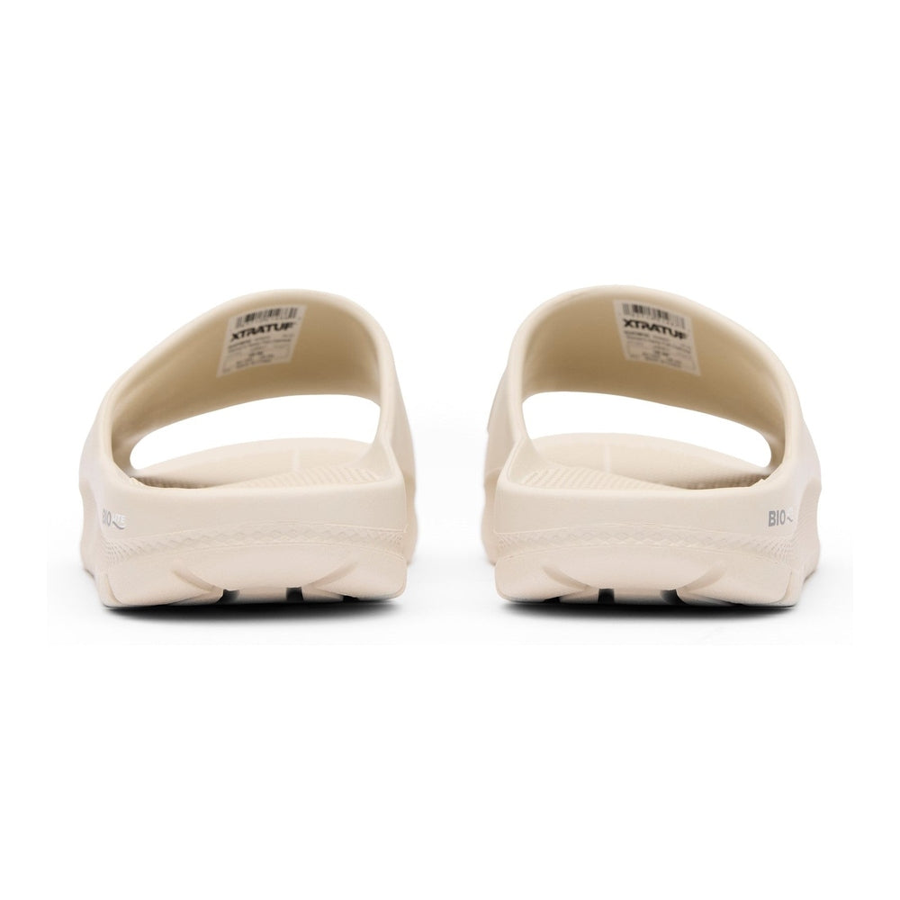 Pair of light beige Apres Fish slides, showing the eco-conscious material and slip-resistant outsole.