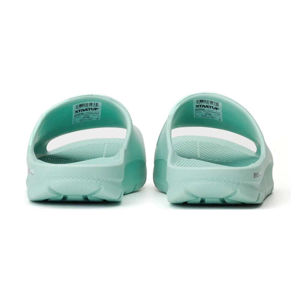 Pair of light green Apres Fish slides, showing the back and textured footbed.