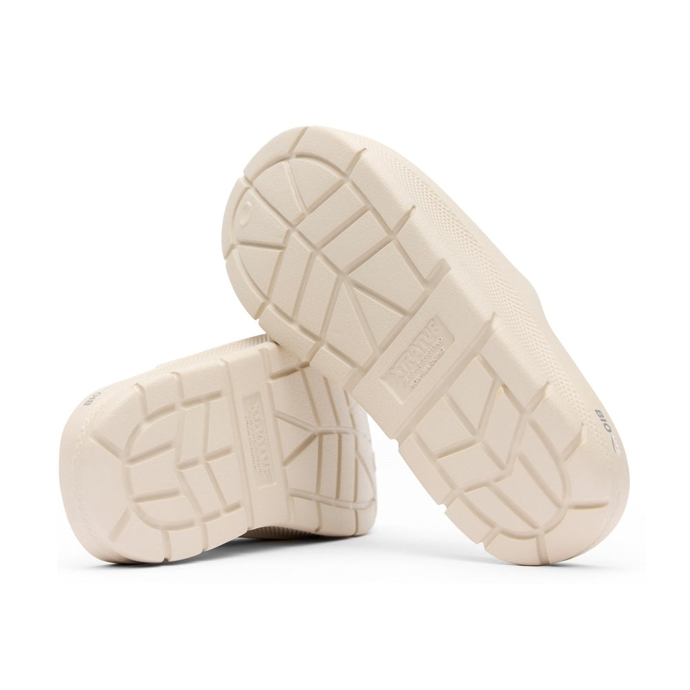 Pair of light beige Apres Fish slides, showing their textured, slip-resistant outsoles.