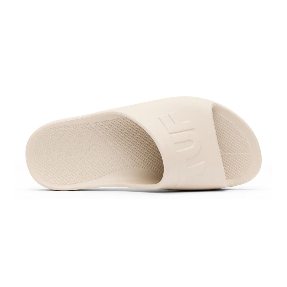 Light beige Apres Fish slide sandal with "HUF" embossed on the strap and textured footbed.