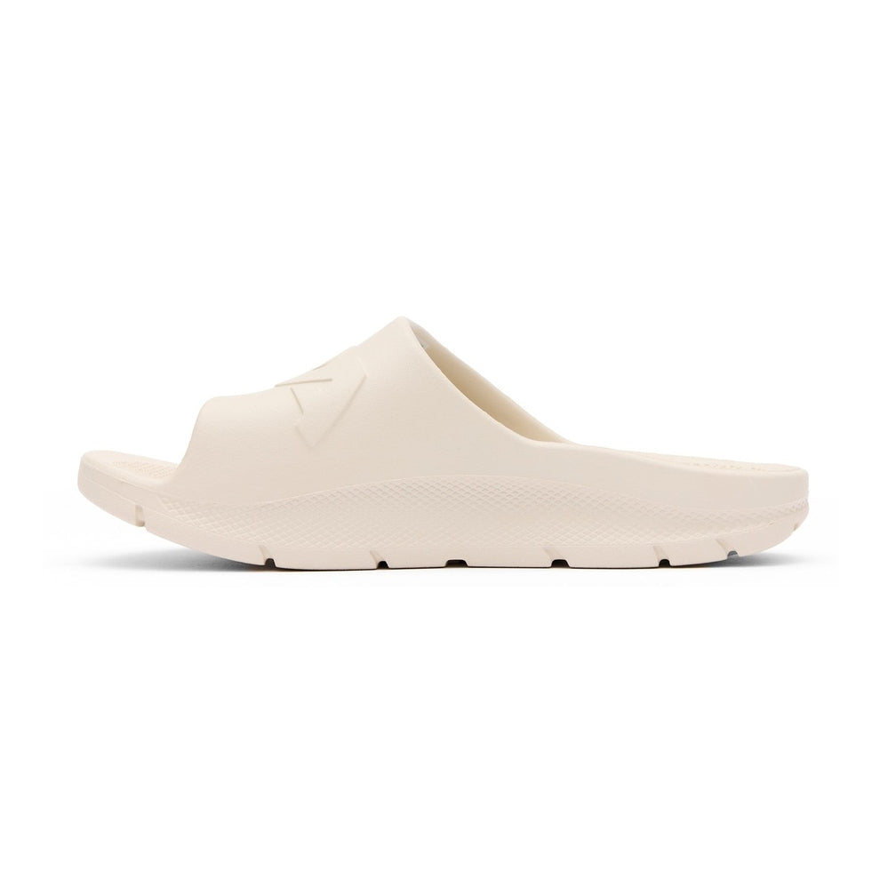 Light beige Apres Fish slide, one-piece eco-conscious material, slip-resistant outsole, side view.