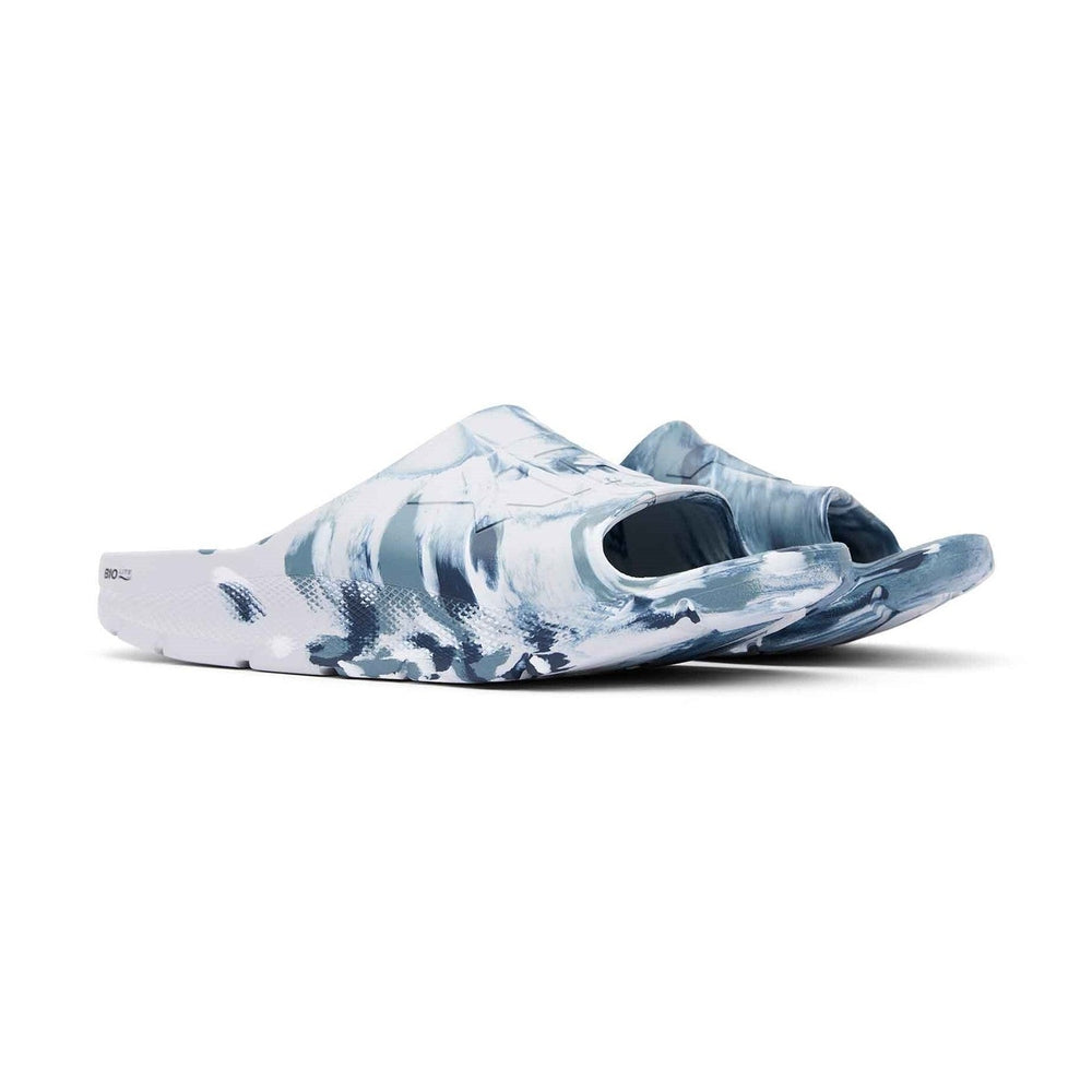 Apres Fish Slide in a blue and white abstract, wave-like pattern, showcasing its one-piece design.